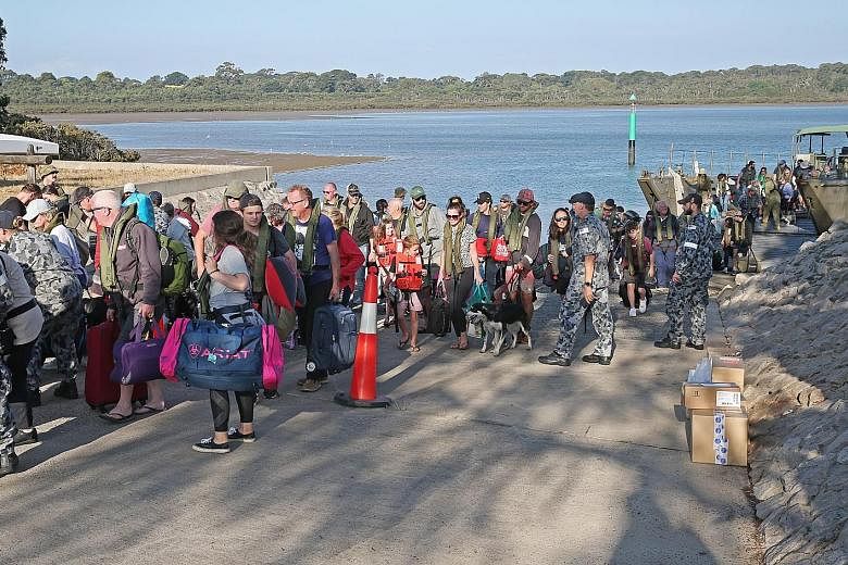 Evacuees from the bush fires landing at Hastings, Victoria, yesterday. Residents of the Australian state's fire-ravaged east are being urged to leave before another heatwave raises the bush fire danger tomorrow. PHOTO: EPA-EFE