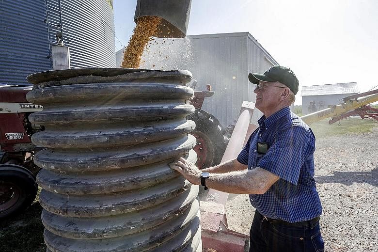 US farmer Don Bloss checking on the operation of an auger transferring corn on his farm in Pawnee City, Nebraska, in this 2018 file photo. Trade tensions between the United States and China cooled with the announcement of a so-called phase one trade 