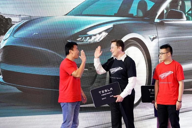 Tesla chief executive Elon Musk on stage with owners of the China-made Tesla Model 3, at a delivery event held in its Shanghai factory on Tuesday. PHOTO: REUTERS