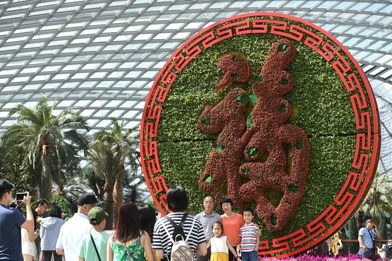 A 5m-tall medallion of the Chinese word fu, which means blessing, showcases deep red kalanchoe blossoms against a striking background of yellow pansies. A pair of "golden" rats made up of sedum and begonia plants now appear green as the flowers have 