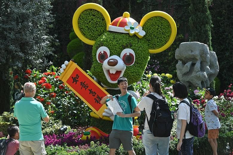 A 5m-tall medallion of the Chinese word fu, which means blessing, showcases deep red kalanchoe blossoms against a striking background of yellow pansies. A pair of "golden" rats made up of sedum and begonia plants now appear green as the flowers have 