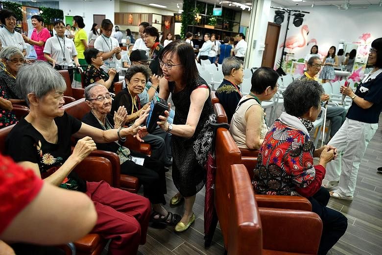 A singalong session at the Home Nursing Foundation's Wellness@Hougang centre yesterday. Ms Michelle Lee (in black), founder and CEO of I'm Soul Inc, is seen here interacting with a senior citizen using a Soundbeam device, which detects movement and t