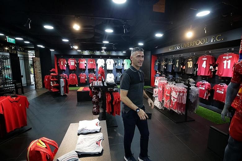 Liverpool ambassador Luis Garcia taking a tour of the club's official merchandise store at Bugis Junction yesterday. The club also have three stores in Thailand, and will open branches in Dubai and Vietnam next week. ST PHOTO: KEVIN LIM