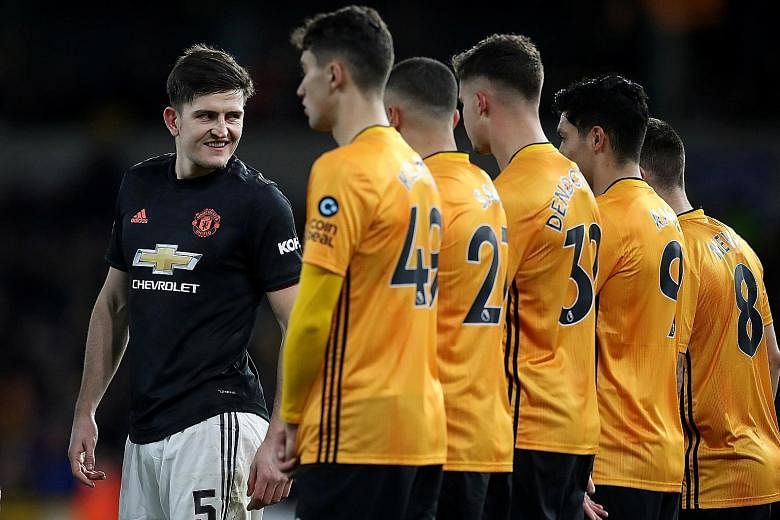 Manchester United centre-back Harry Maguire (left) eyeing up the Wolves defence during their goal-less FA Cup third round match last Saturday. He has since been out with a hip injury but could face Norwich today. PHOTO: REUTERS