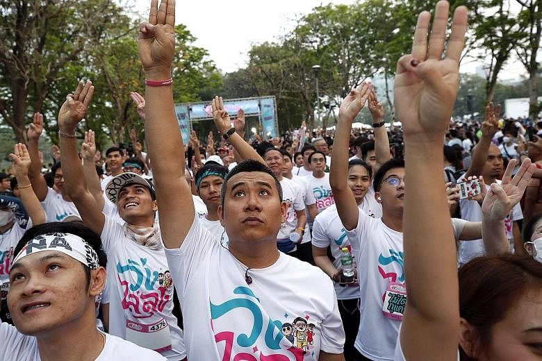 Participants flashing a three-finger salute as they took part in the Run Against Dictatorship event at a public park in Bangkok yesterday.