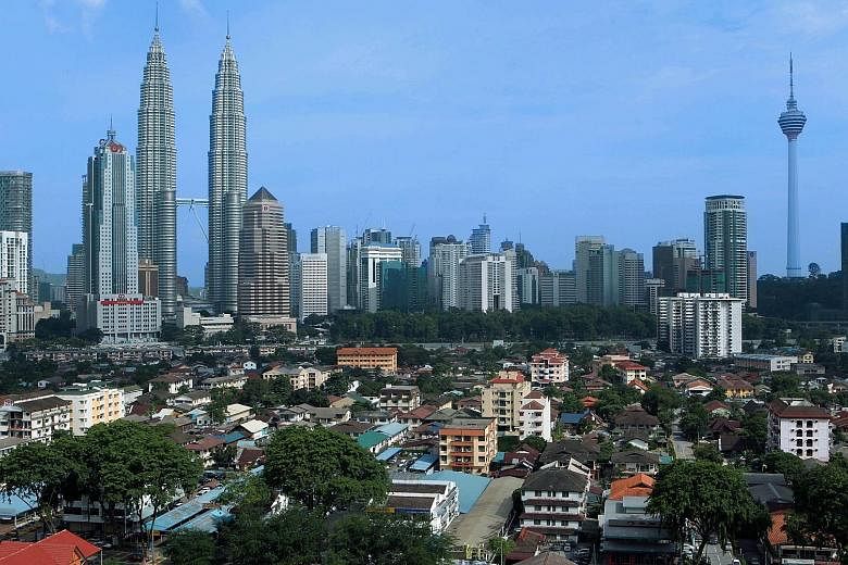 Kampung Baru sits beneath the Kuala Lumpur city skyline with the Petronas Twin Towers and KL Towers looming above it. The sprawling 120-year-old village comprises old village houses and ageing apartments. PHOTO: BLOOMBERG A model of the new Kampung B