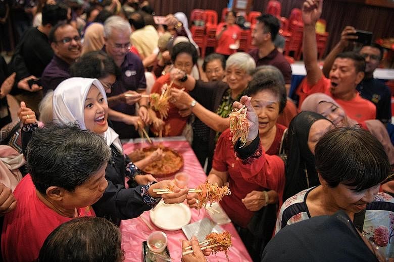 Ms Rahayu Mahzam, MP for Jurong GRC and an adviser to the PA Mesra youth sub-committee, joining in the lo hei session with seniors from Thye Hua Kwan Social Service Hub in Bukit Batok East and the Concern and Care Society during the event at Bukit Ba