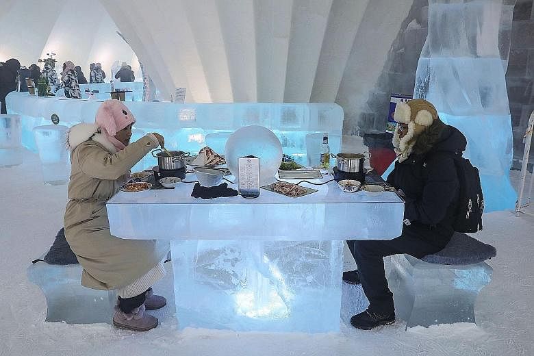 People enjoying hotpot inside an igloo in Harbin in China's north-eastern Heilongjiang province, during the annual Harbin International Ice and Snow Festival. The festival, featuring glittering palaces and fantastical scenes sculpted out of ice, has 