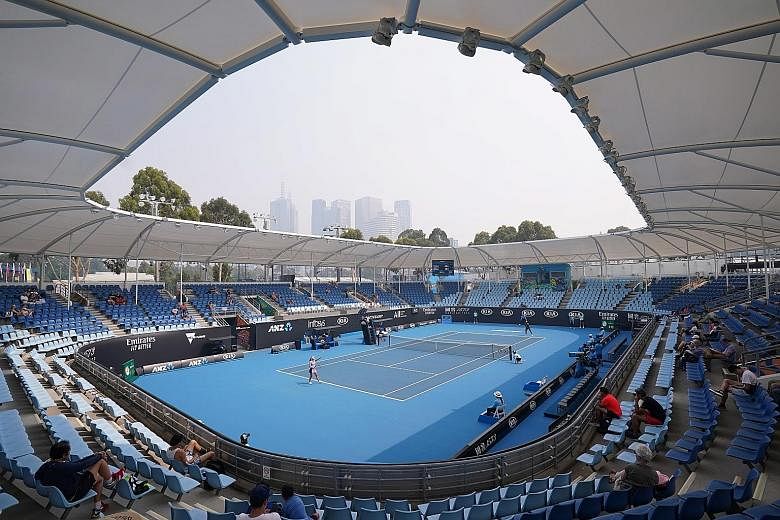 Left: Players have been struggling through their qualifying matches for the Australian Open at Melbourne Park with the air quality index reaching unhealthy highs. Above: The haze is affecting viewers in the stands as well, with this fan opting for a 