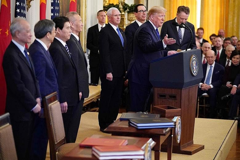 US President Donald Trump addressing a press conference at the White House before signing the deal with China. Beside him are China's Vice-Premier Liu He (fourth from left) and US Vice-President Mike Pence.