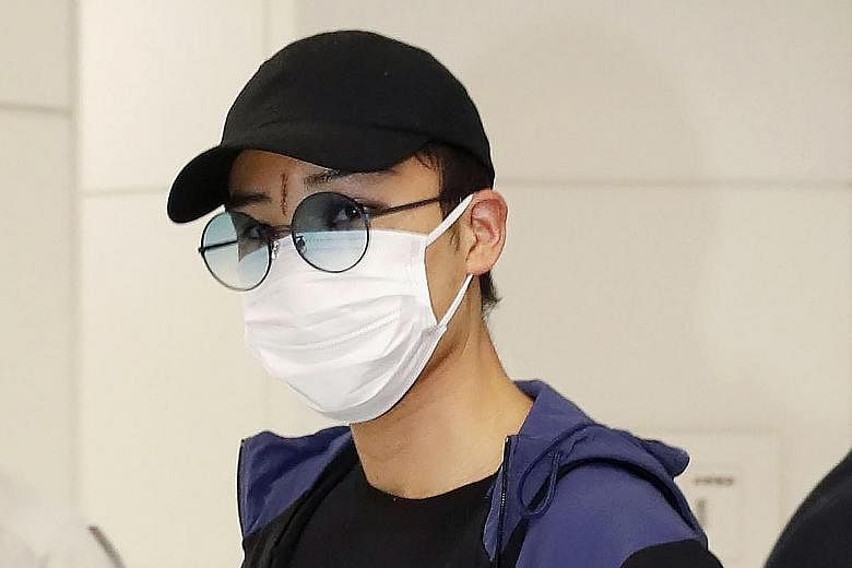 Japanese top-ranked shuttler Kento Momota, wearing a mask, arriving at Narita Airport after his flight from Malaysia.