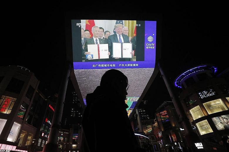 A TV screen outside a shopping mall in Beijing showing US President Donald Trump and Chinese Vice-Premier Liu He during the signing of the phase one trade agreement last Thursday. Mr Trump and Chinese Vice-Premier Han Zheng are expected to deliver sp