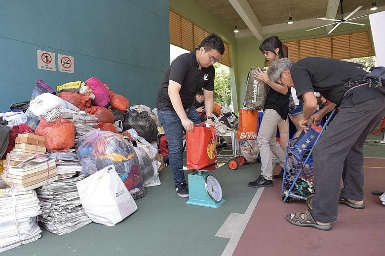 Residents of South West District swopping their recyclables for groceries or vouchers at Chua Chu Kang Community Club yesterday. The annual Clean Up South West! is in its 15th iteration this year.