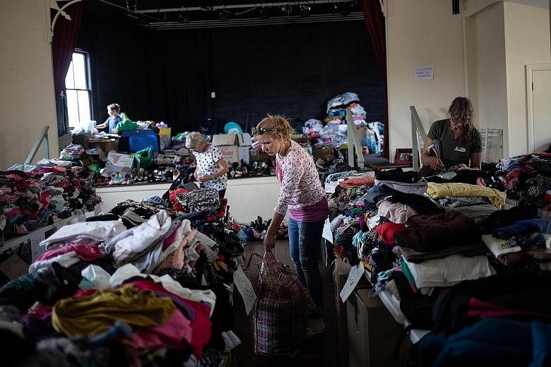 Volunteers arranging donated clothes at a centre in Cobargo town in New South Wales state. As bush fires have ravaged Australia, the outpouring of donations from celebrities, business moguls and people around the world has left the country trying to 