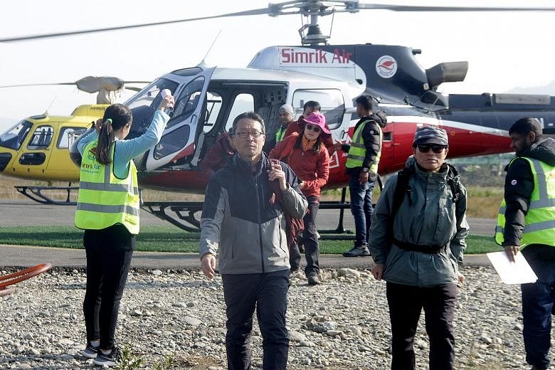Tourists arriving last Saturday at the Pokhara Airport in Nepal following a rescue operation from Mount Annapurna base camp. Four South Koreans and three Nepalis remain missing after last Friday's avalanche.