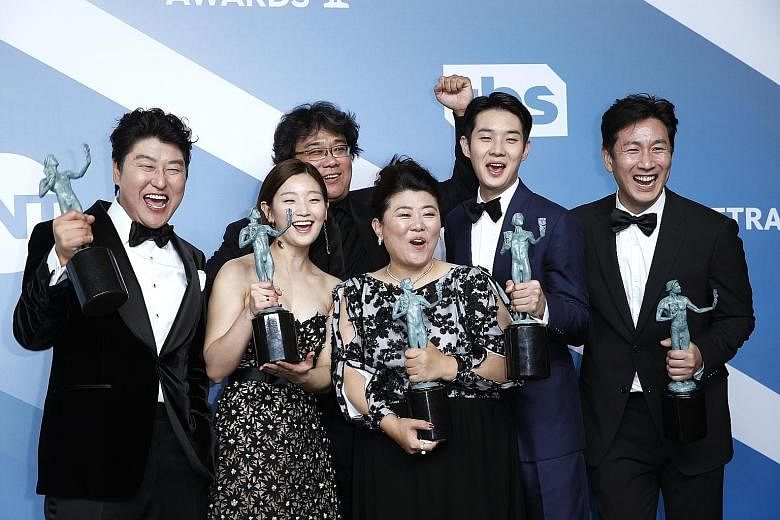 Director Bong Joon-ho (third from left) with the cast of Parasite (from left) Song Kang-ho, Park So-dam, Lee Jeong-eun, Choi Woo-shik and Lee Sun-kyun, who took the top prize of best movie ensemble cast. Jennifer Aniston (top) won the best actress in