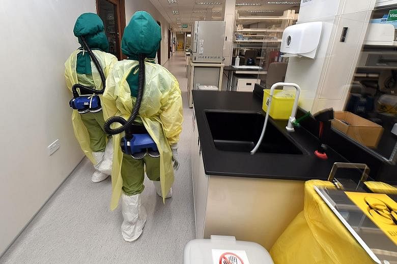 The negative-pressure ward (above) at the National Centre for Infectious Diseases, where air flows only into the rooms, not out of them. Medical workers (right) will don personal protective equipment and powered air purifying respirators. ST PHOTOS: 