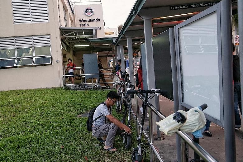 Some Malaysians who commute to work in Singapore are still riding their e-scooters into the Republic (above), but have been parking them near the Woodlands Checkpoint since the devices are banned from footpaths in Singapore. A number of workers lock 