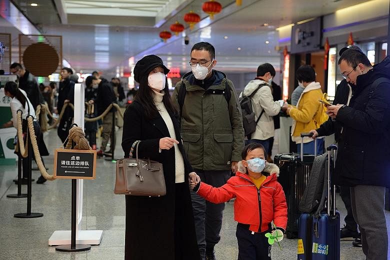 Passengers wearing masks at the Hongqiao Railway Station in Shanghai yesterday as the Wuhan virus spreads across China. The Chinese New Year period is a peak travel season and this "is a tremendous challenge, which could complicate the disease diffus