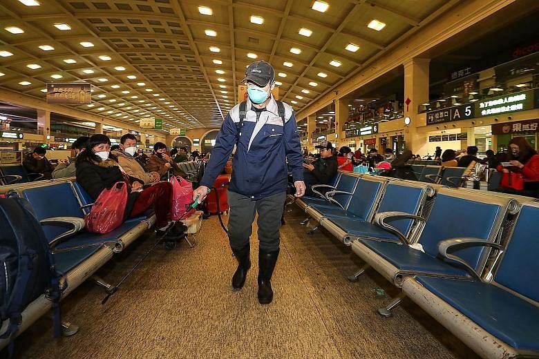 A worker disinfecting an area in the Hankou Railway Station in Wuhan yesterday. The authorities fear the number of infected cases will soar as millions travel across the country during the Chinese New Year holidays.