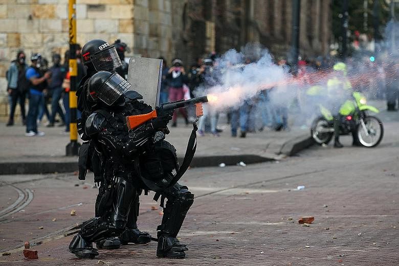 Riot police in action during a protest against the government of Colombia's President Ivan Duque, in Bogota on Tuesday. What began as a general strike has morphed into a wider display of discontent over his economic policies, unemployment, political 