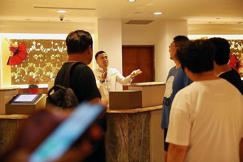 Mr Kelvin Yu (in blue T-shirt), who was staying at Shangri-La's Rasa Sentosa Resort & Spa with his family, asking a hotel employee yesterday which room the infected guest had stayed in. ST PHOTO: TIMOTHY DAVID