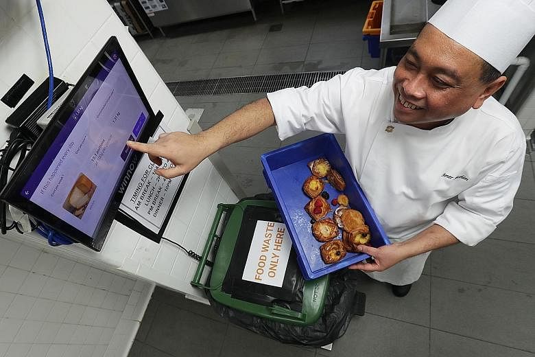 Shangri-La Hotel Singapore's kitchen division trainer Mohd Amer Hashim demonstrating how the hotel tackles food wastage using the Winnow system, which weighs and tracks food items left over at buffets and catered meals, and provides data to guide che