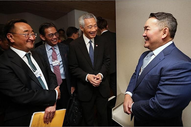 From left: Prime Minister Lee Hsien Loong meeting Mongolian President Khaltmaagiin Battulga, Dutch Prime Minister Mark Rutte and German Chancellor Angela Merkel in Davos yesterday. PM Lee said it is not hard to make the argument that Singapore needs 