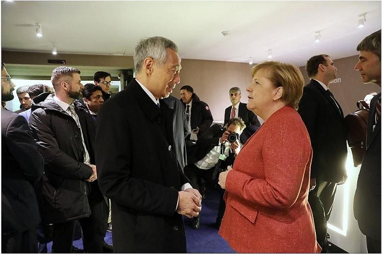 From left: Prime Minister Lee Hsien Loong meeting Mongolian President Khaltmaagiin Battulga, Dutch Prime Minister Mark Rutte and German Chancellor Angela Merkel in Davos yesterday. PM Lee said it is not hard to make the argument that Singapore needs 