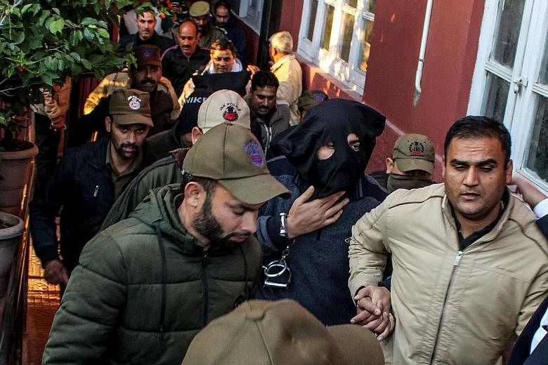 Suspended deputy superintendent of police for Jammu and Kashmir Davinder Singh (hooded) at a court in Jammu last Thursday. He was arrested for helping two terrorists travel out of the state on Jan 11.