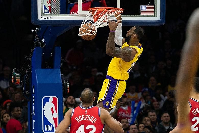 LA Lakers forward LeBron James dunking the ball over Philadelphia 76ers forward Al Horford on the way to his new career total of 33,655 points. The Lakers, however, lost 108-91 in Philadelphia. 