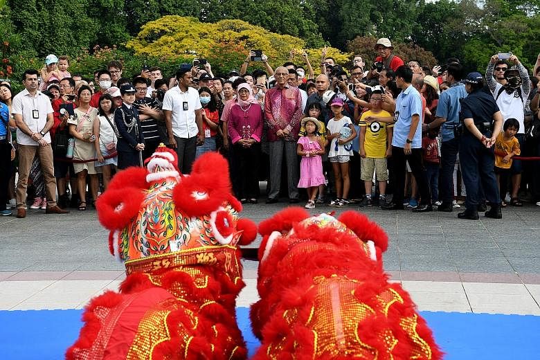 Above: Some visitors wearing masks at the Istana's Chinese New Year open house yesterday. ST PHOTOS: KHALID BABA Left: President Halimah Yacob and her husband, Mr Mohamed Abdullah Alhabshee, joining guests to watch a lion dance at the open house. She