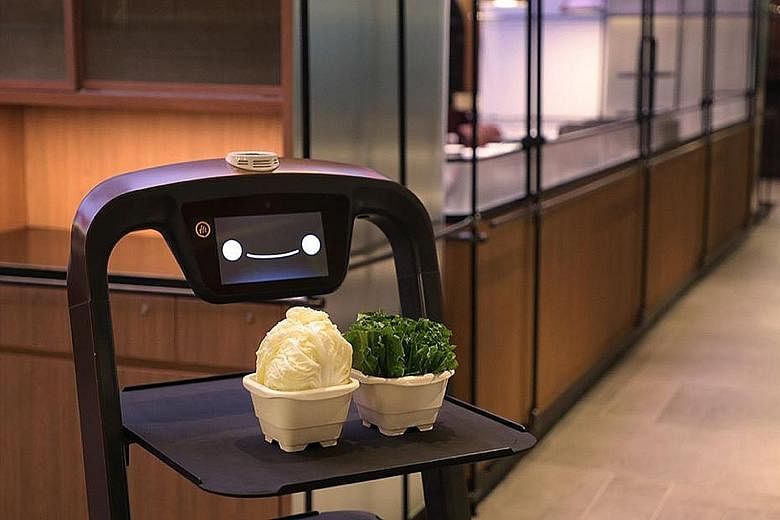 A robot server at Haidilao's Marina Square outlet carrying hotpot ingredients from the kitchen to tables - a task that can be done within minutes.