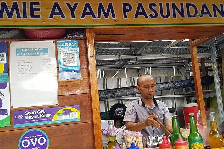 A noodle street vendor in Indonesia that accepts payment from e-wallets Go-Pay and Ovo. At least 39 e-wallet apps have been licensed by the central bank. The total value of transactions made through e-wallets was US$1.5 billion (S$2 billion) in 2018,