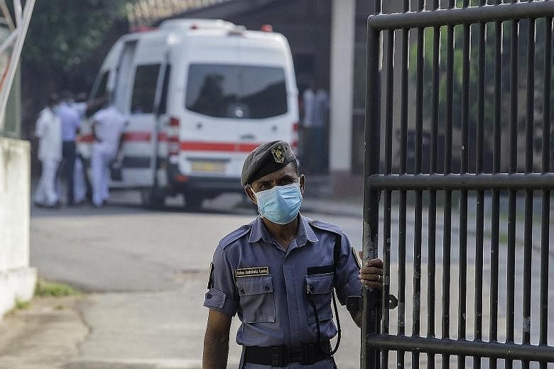 A security guard at the entrance to Sri Lanka's National Institute of Infectious Diseases in Colombo yesterday. A Chinese citizen has been placed in isolation at the institute after testing positive for the coronavirus. A driver getting his temperatu