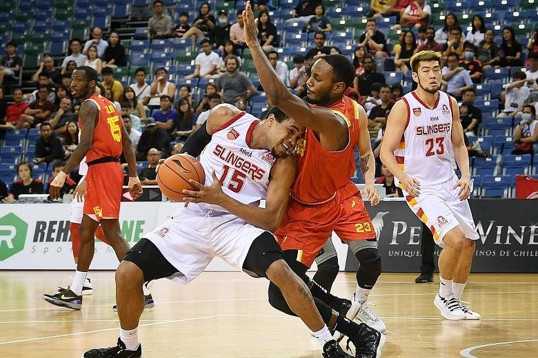 Singapore Slingers' Xavier Alexander (No. 15) meeting resistance in the form of his Saigon Heat marker, as teammate Delvin Goh looks on. The Slingers won the game at the OCBC Arena 101-67. 