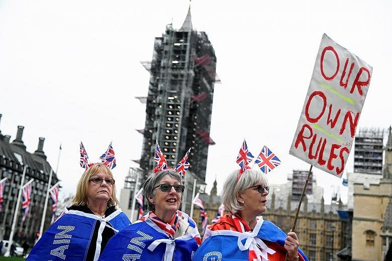 Pro-Brexit supporters at Parliament Square in London yesterday. Britain begins an 11-month transition period after its exit from the European Union. PHOTO: REUTERS
