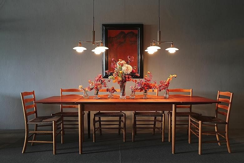A dining set-up showing a 1960s Hans Wegner table ($8,000 from 1B2G Fine Vintage Furniture) with a matching set of Kaare Klint Church Chairs ($1,800 each), manufactured by Fritz Hansen in 1964. The pendant lights are Poul Henningsen’s rare Stammkrone desi