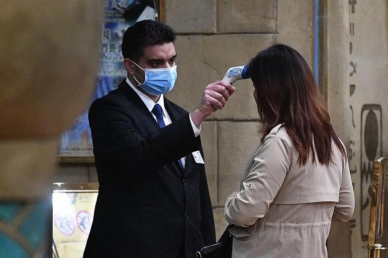 A woman entering the casino of the New Orient Landmark Hotel in Macau on Jan 22 getting her temperature checked.
