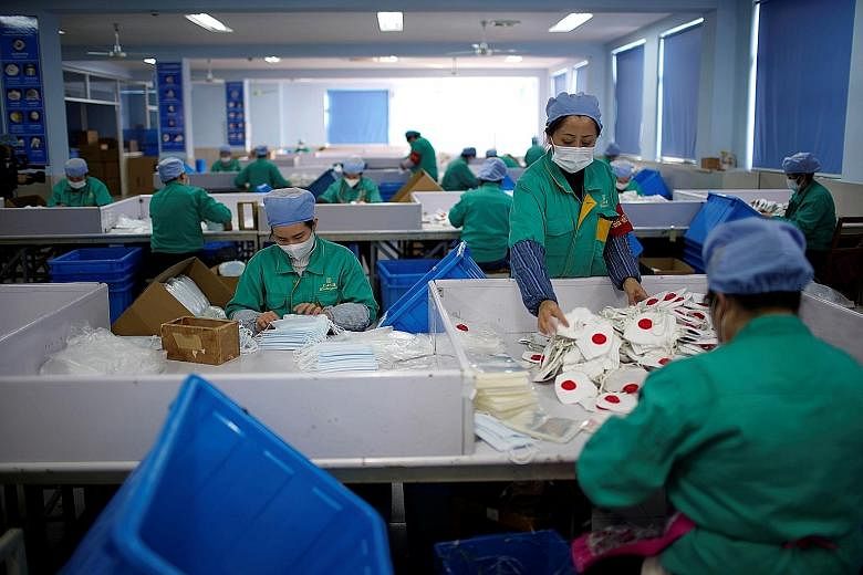 Workers in a mask production line at a factory in Shanghai on Friday. China's Ministry of Industry and Information Technology said the country produces eight million masks every day. PHOTO: REUTERS