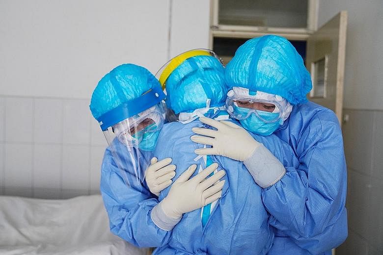 Medical staff members hugging one another in an isolation ward at a hospital in Zouping, in China's eastern Shandong province. The death toll in China has hit 259, with more than 2,000 new infections confirmed, bringing the country's total to 11,860 