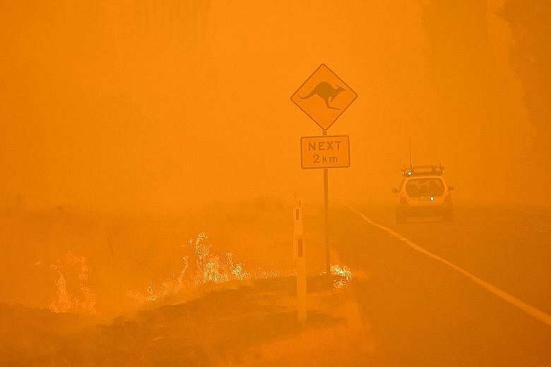 The sky turning orange-red as bush fires burn near the town of Bumbalong, south of Canberra, yesterday. The Australian Capital Territory, home to the country's capital Canberra, declared a state of emergency on Friday in anticipation of severely hot 