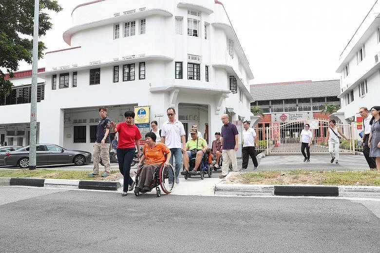 Tanjong Pagar GRC grassroots adviser Indranee Rajah joining wheelchair users as they travelled on an enhanced barrier-free ramp in Tiong Bahru-Seng Poh estate yesterday. The changes were made in the area between SPD Ability Centre and Tiong Bahru Mar