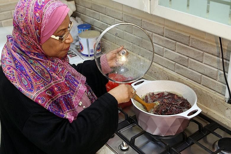 Ms Moudi Al-Miftah cooks a potful of locusts at her home in Al-Ahmadi. She puts them into boiling stock, where they turn red, filling her kitchen with an aroma similar to stewing mutton. A locust vendor in a market in Kuwait with a bag of edible inse