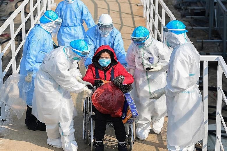 Medical staff transferring a patient to the newly completed Huoshenshan Hospital in Wuhan, Hubei province, yesterday. Two temporary hospitals have been built in under two weeks to ease the bed shortage.
