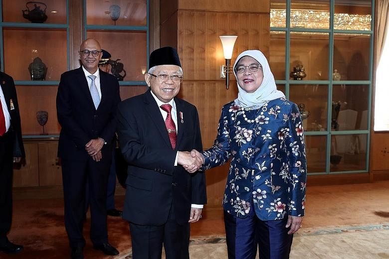 Indonesia's Vice-President Ma'ruf Amin meeting President Halimah at the Shangri-la Hotel in Jakarta yesterday. PHOTO: LIANHE ZAOBAO Singapore President Halimah Yacob, accompanied by Indonesian President Joko Widodo, inspecting a guard of honour at th