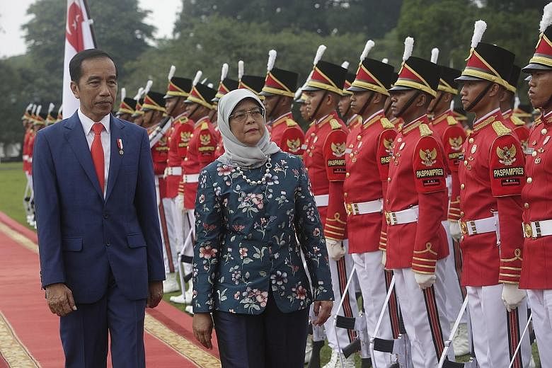 Indonesia's Vice-President Ma'ruf Amin meeting President Halimah at the Shangri-la Hotel in Jakarta yesterday. PHOTO: LIANHE ZAOBAO Singapore President Halimah Yacob, accompanied by Indonesian President Joko Widodo, inspecting a guard of honour at th