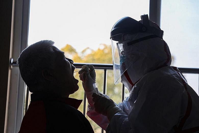 Samples being taken to be tested for the new coronavirus at a quarantine zone in Wuhan on Tuesday. Gilead said it has started clinical trials of patients in China using remdesivir.