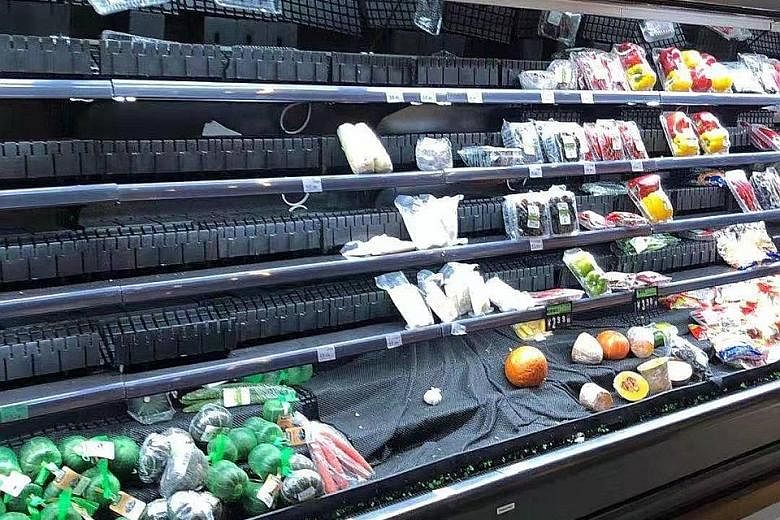 Empty shelves at a supermarket in Wuhan on Jan 23, when there was panic buying after it was announced that the city would be put under lockdown. Singaporean K. Ho, who lives in Wuhan, said the shelves were fully stocked again the next day. PHOTO: COU