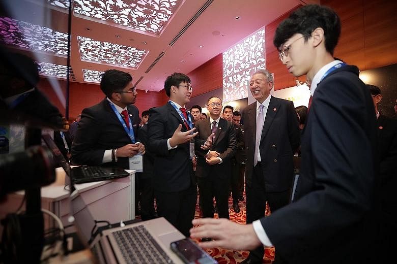 Senior Minister and Coordinating Minister for National Security Teo Chee Hean with Singapore Polytechnic students (from left) Ashwin Dinesh, Davis Zheng and Tristan Voon at the 12th Global Space and Technology Convention in Grand Hyatt Singapore yest